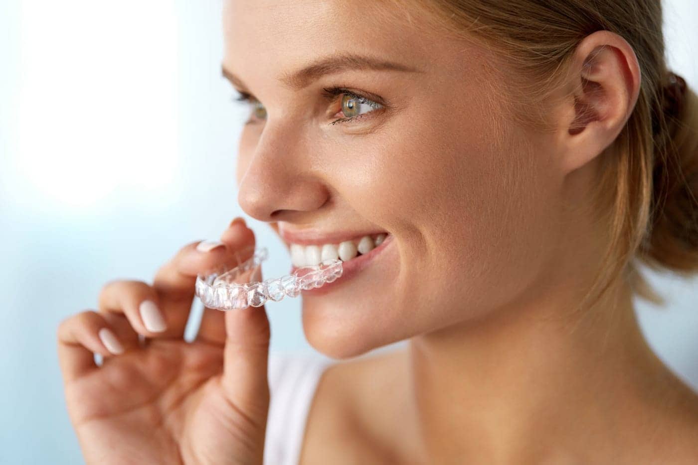 Paciente colocándose un alineador transparente Invisalign en Carabanchel