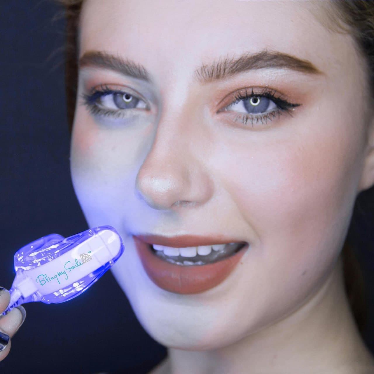 Paciente usando luz LED de blanqueamiento dental con producto visible